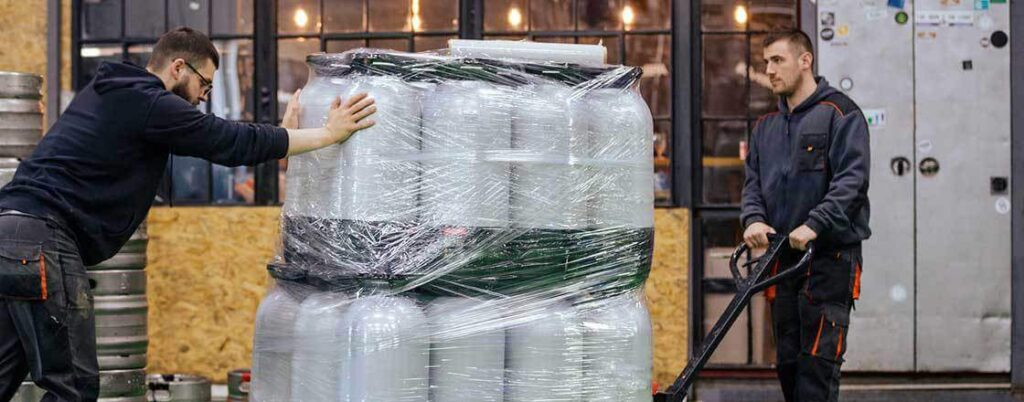 Warehouse workers moving  palletized drums