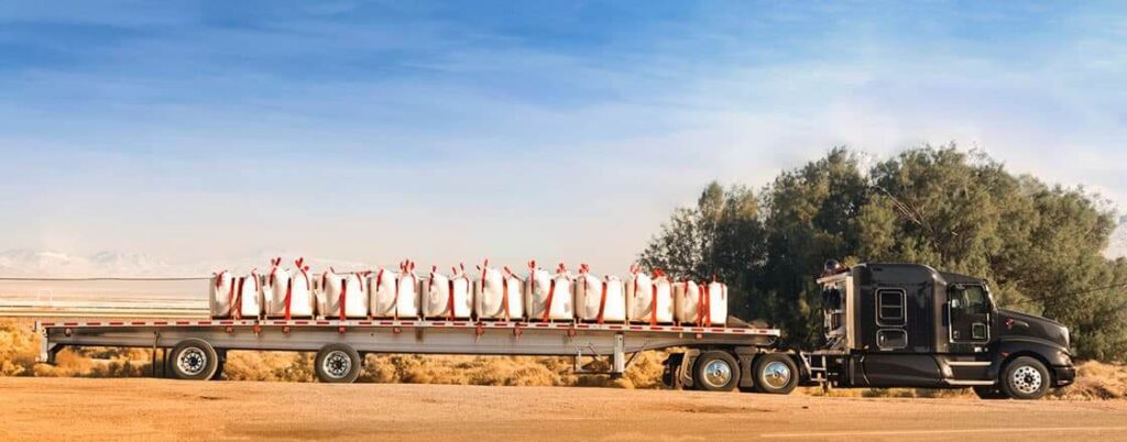 A flatbed truck transporting bags of soda ash